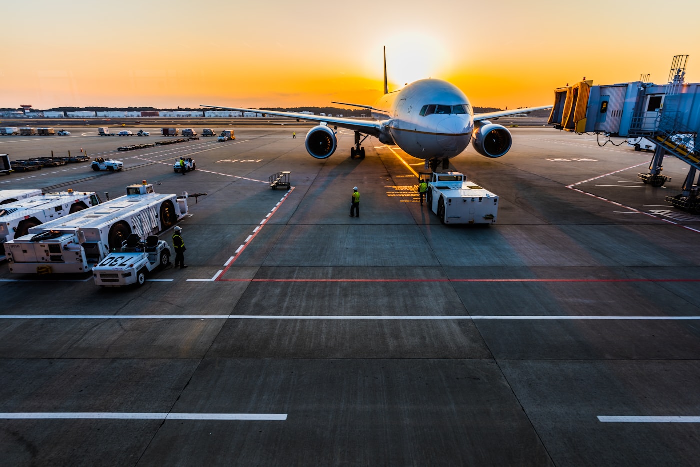 Ground crew servicing an aircraft at sunset